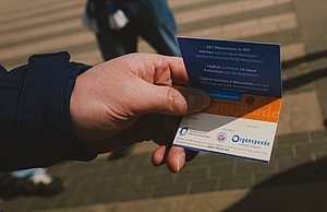 Hand mit einem Organspendeausweis in Kooperation mit Hansa Rostock.